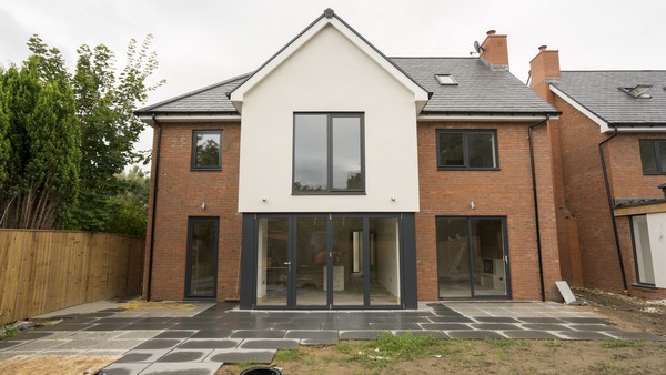 New build development featuring a range of Anthracite Grey (Ral 7016) grey aluminium windows and doors. Here we can see a set of Centor aluminium bifolding doors, and a sliding door from The Knight Collection.